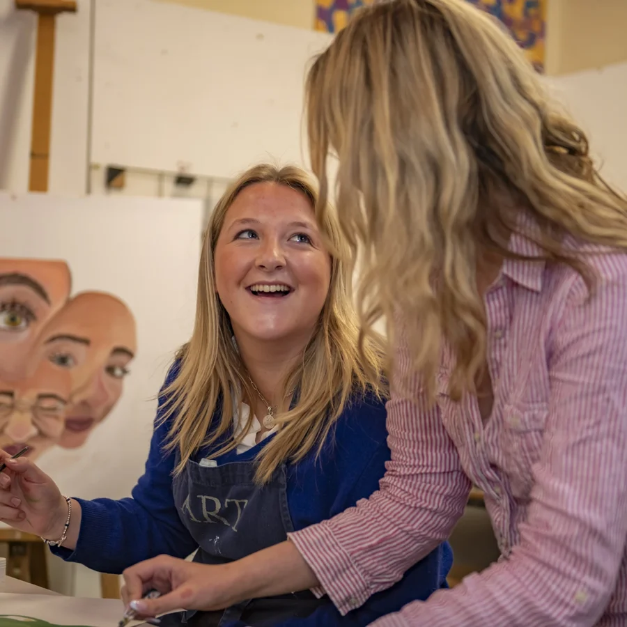 A teacher and a pupil sharing a fun moment in an art class at Barnard Castle School.