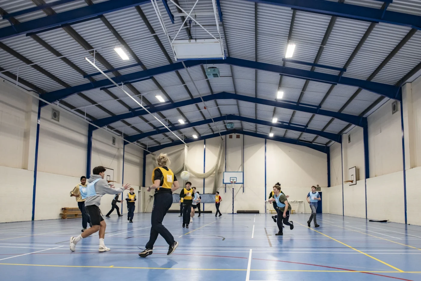 Barnard Castle School boarders playing netball in a sports hall.