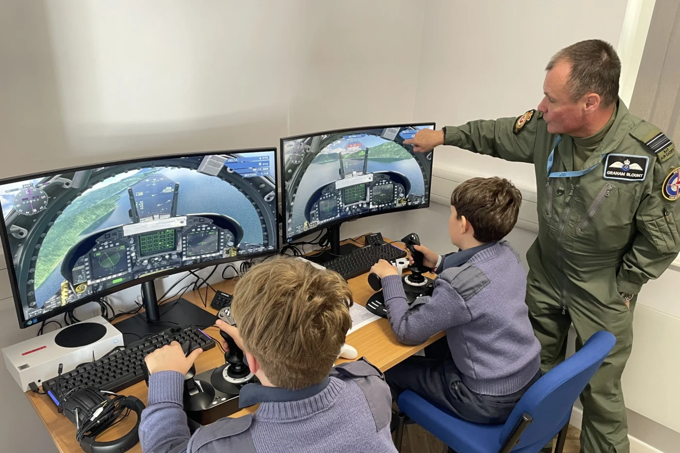 Two boys practicing RAF simulation on screen.