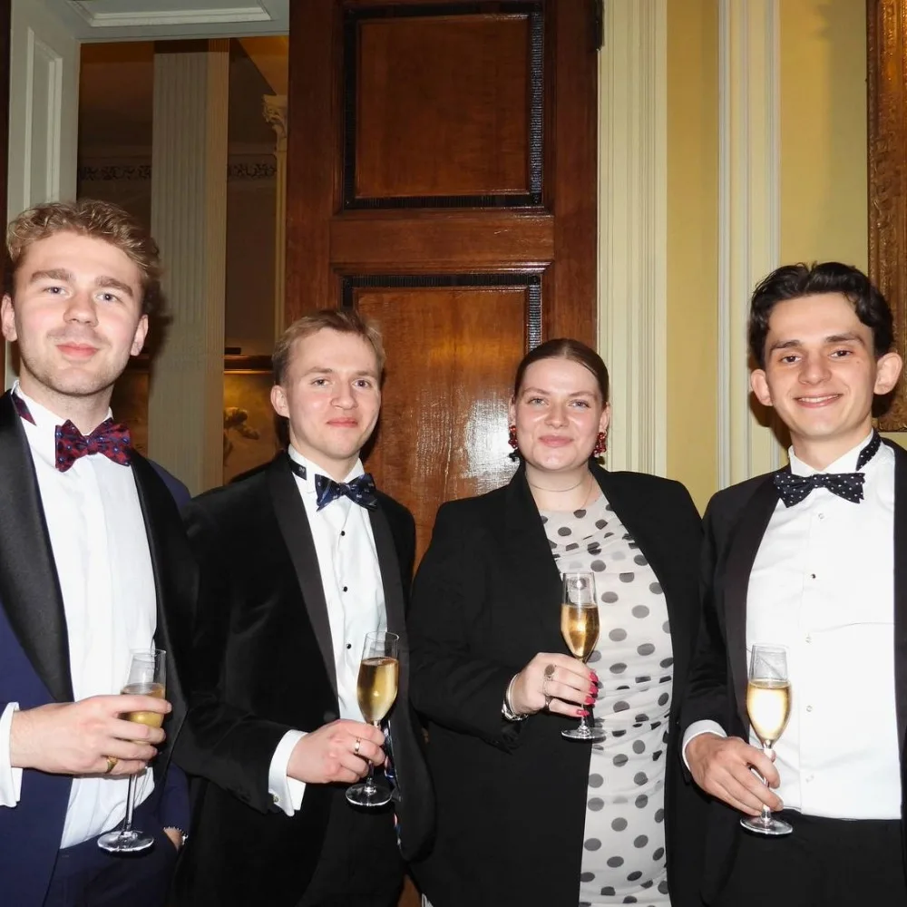 A group of Old Barnardians holding drinks at a fundraising event.