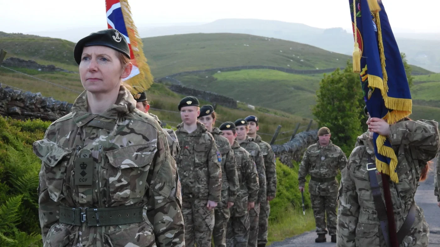 Rows of people in military uniform standing to attention.