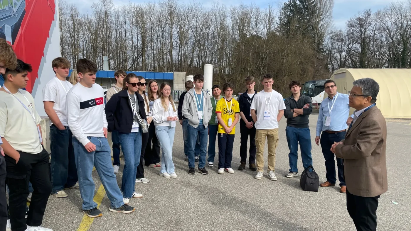 A group of Barney students listening to a man.